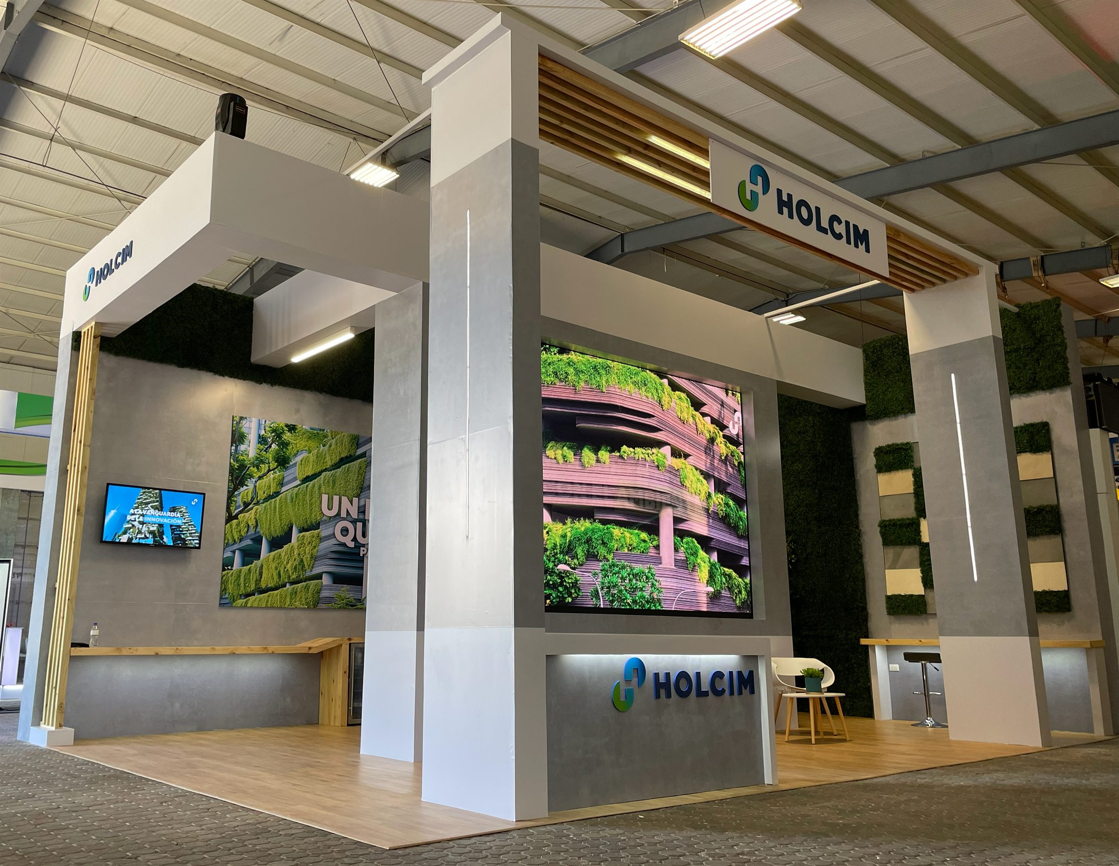 Stand corporativo de Holcim terminado, con pantallas, vegetación y acabados arquitectónicos