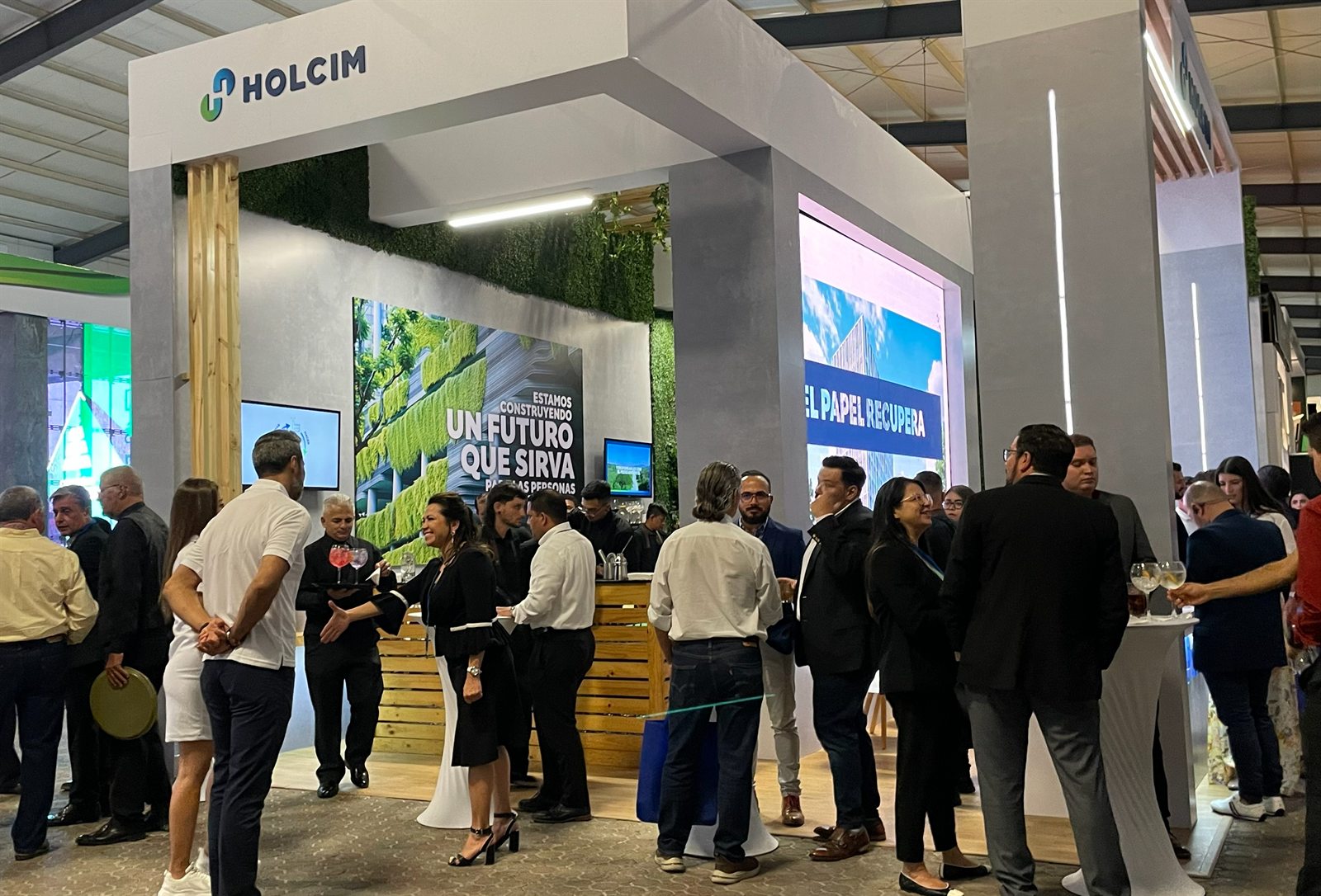 Asistentes reunidos dentro del stand de Holcim durante la exposición