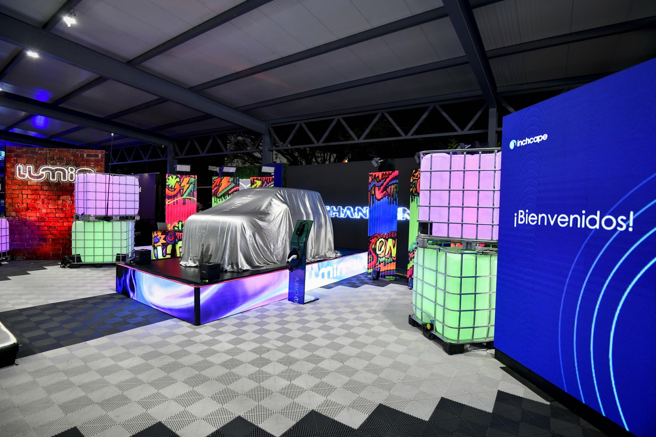 Escenografía del lanzamiento de LUMIN para INCHCAPE, con vehículo cubierto, pantallas LED e iluminación de marca